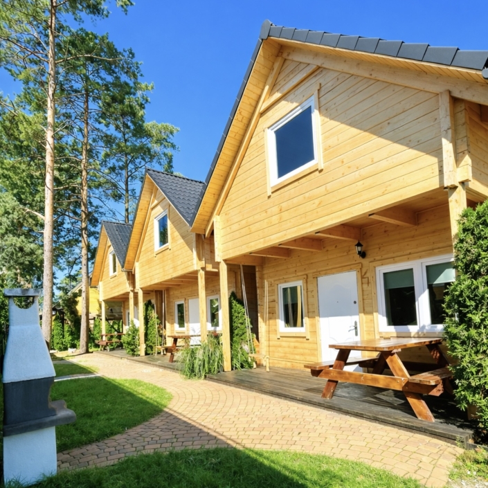 Drewniane domki Morska Fala w Pobierowie otoczone sosnami blisko plaży