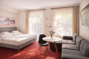 Pokój czteroosobowy z łóżkiem małżeńskim i rozkładanym narożnikiem oraz wyjściem na balkon – Morska Fala Pobierowo